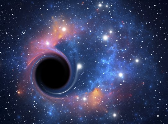 Black hole. Computer artwork representing a black hole against a starfield.
